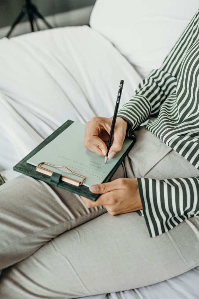 A clinician writing up notes on a clipboard during a home visit